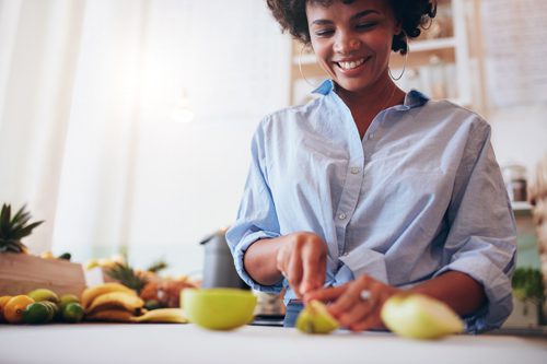 happy woman cutting fruit - diet