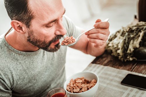man eating healthy breakfast cereal - immune system