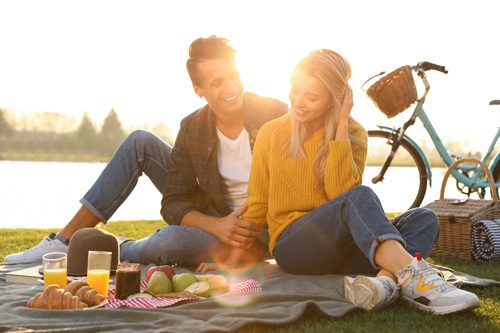 young couple having a picnic near a pond - sober dating